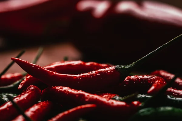 Red and green chili peppers close up on wooden background — Stock Photo, Image