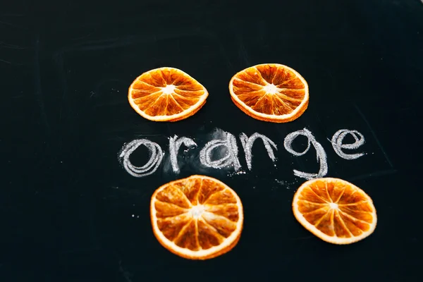 Quattro tazza tagliata arancione su una tavola di sfondo nero — Foto Stock