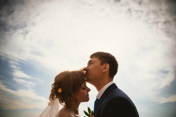 Jovem noiva e noivo no céu de fundo — Fotografia de Stock
