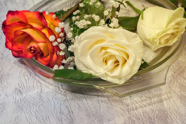 Les roses sur la table sur un plat en verre . — Photo