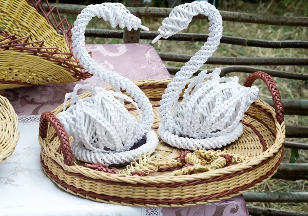 Figuras decorativas de cisnes em uma travessa de vime . — Fotografia de Stock