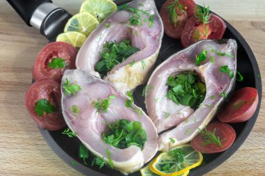 Tavada, sazanlar soyulur ve kızartılmaya hazır sebzelerin yanında dilimlenir. Üst görünüm, yakın çekim.