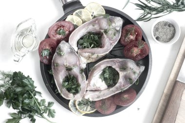 Tavada, sazanlar soyulur ve kızartılmaya hazır sebzelerin yanında dilimlenir. Üst görünüm, yakın çekim.