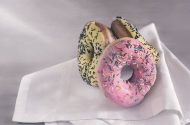 Masanın üzerinde sarı krema ve çikolata parçalarıyla kaplı lezzetli bir pasta var. Ön manzara, yakın plan..