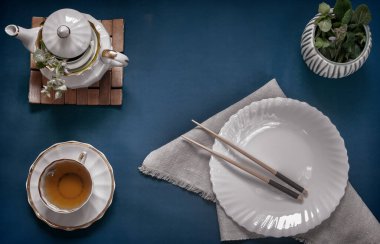 Boş beyaz tabak, yemek çubuğu ve bitki çayı.