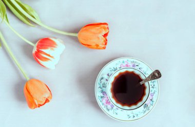 Alternatif kahve yerine, beyaz bir fincanda masanın üzerinde doğal hindibasından yapılmış sıcak kafeinsiz bir içecek. Yakınlarda laleler büyür. Üst görünüm, alanı kopyala