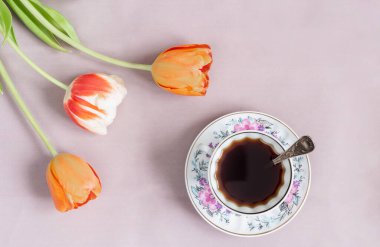 Yanında laleler olan kafeinsiz sıcak hindiba içeceği.