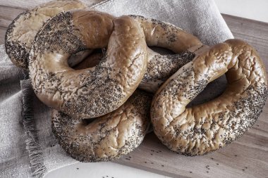 Kesme tahtasında haşhaş tohumlu simit.