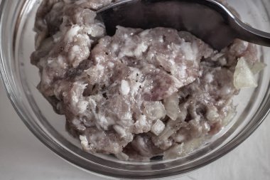 Masanın üzerinde cam bir kasede, soğanlı ve baharatlı et kıymalı hamur tatlısı ve pirzola yapmak için. Yakın çekimde sunuldu. Ev yapımı yemek..