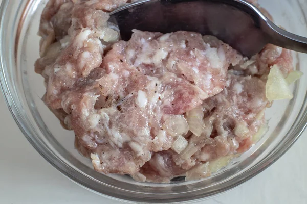 Masanın üzerinde cam bir kasede, soğanlı ve baharatlı et kıymalı hamur tatlısı ve pirzola yapmak için. Yakın çekimde sunuldu. Ev yapımı yemek..