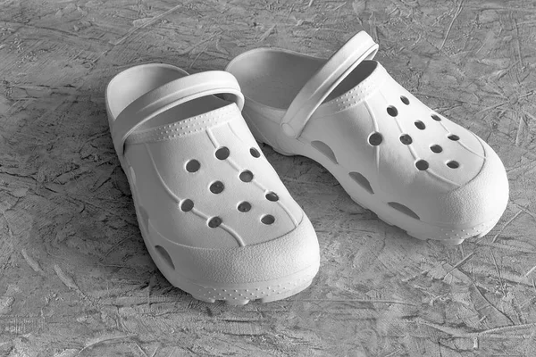 Un par de sandalias blancas Crocs para mujer Imagen de stock