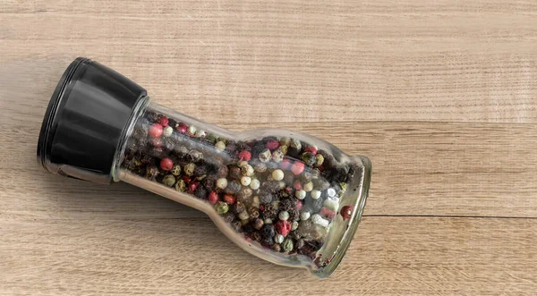 Diverse variëteiten peper in een glazen fles — Stockfoto