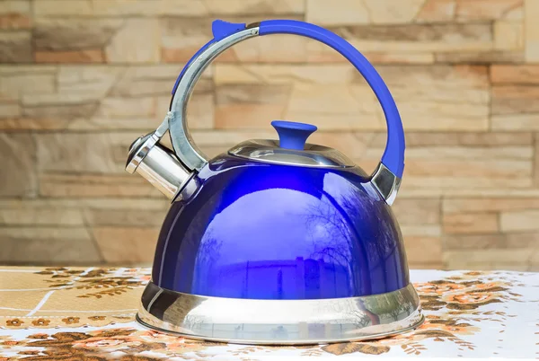 Bright blue kettle on the tablecloth table. — Stock Photo, Image