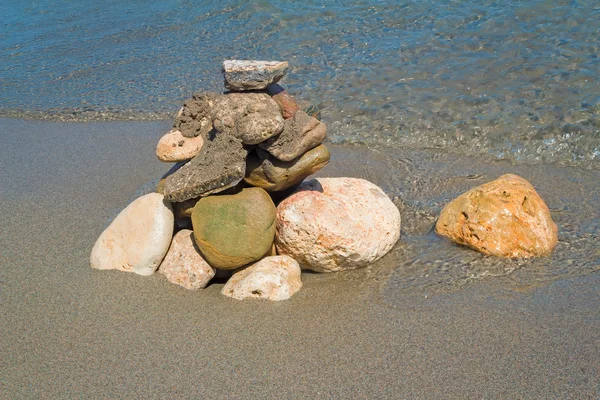 Small sea stones on the seashore, covered with a sea wave. — Stock Photo, Image