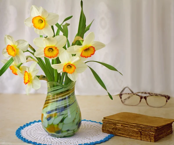 Des narcisses en fleurs dans un vase sur une table . — Photo