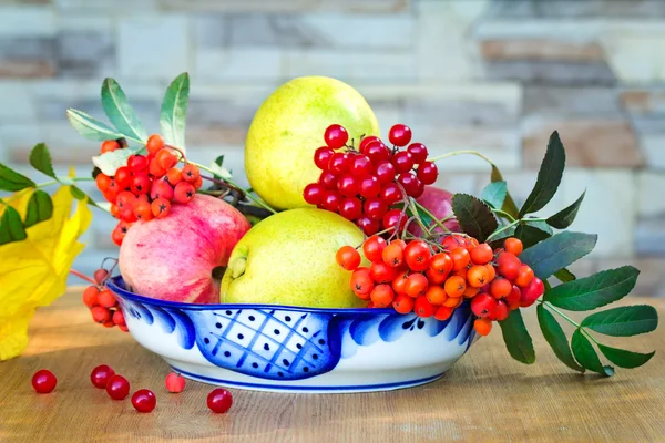 Stilleven: boeken en fruit en bessen in een mooie vaas. — Stockfoto