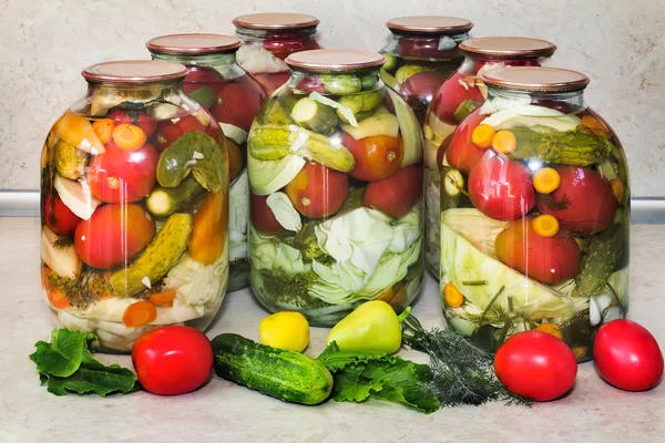 Une variété de légumes en conserve dans des bocaux en verre. — Photo