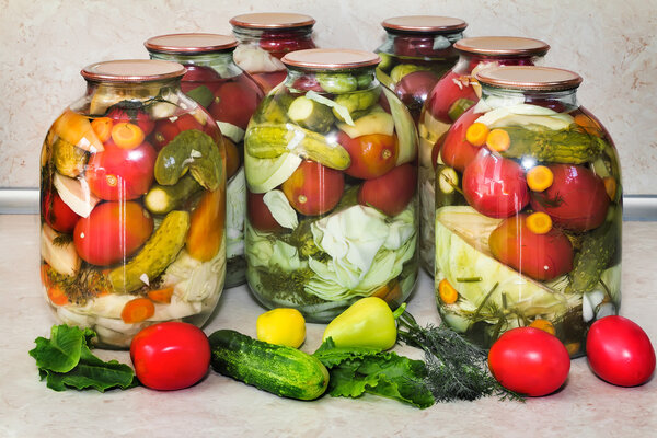 A variety of canned vegetables in glass jars.