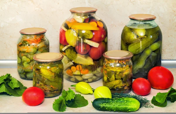 Ingeblikte komkommers met kruiden in glazen potten. — Stockfoto