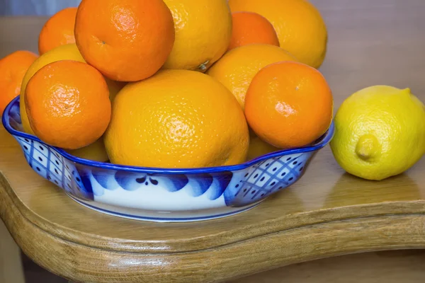 Sinaasappelen en mandarijnen in een prachtige keramische vaas. — Stockfoto