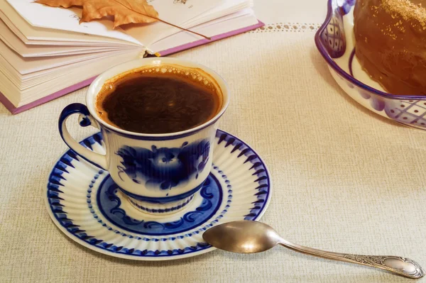 Uma xícara de café preto e bolo na mesa . — Fotografia de Stock