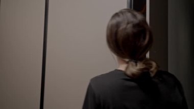 Kadın, gri ceketini çıkarmak için gardıroba uzandı.