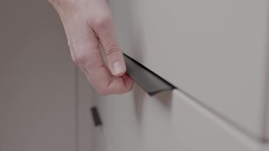 Mutfak çekmecesini açmak için modern kolları çeken bir kadın. Ev organizasyonu kavramı