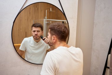 Adam evde banyo rutinini yapıyor.