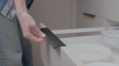 Beyaz mutfak çekmecesini açmak için modern bir el çekişi. Ev organizasyonu ve mutfak deposu kavramı