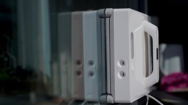 Cam camına su püskürterek hareket eden cam temizleme robotunu kapatın. Otomatik temizlik süreci ve akıllı ev teknolojisi kavramı