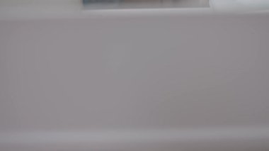 Kadın elinin mutfak çekmecesinden beyaz tabakları çıkarmasına yakın çekim. Mutfak organizasyonu kavramı