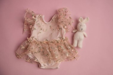 Oyuncak ve çiçekli yeni doğmuş giysiler fotoğraf için güzelce katlanmış bir konumda.