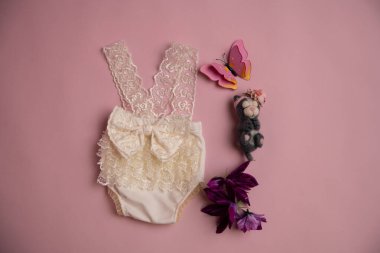 Oyuncak ve çiçekli yeni doğmuş giysiler fotoğraf için güzelce katlanmış bir konumda.