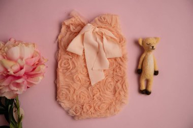 Oyuncak ve çiçekli yeni doğmuş giysiler fotoğraf için güzelce katlanmış bir konumda.