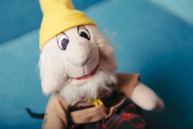 Sevimli oyuncak cüce peluş yeşil bir arka plan sarı şapkalı