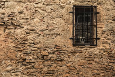 Eski bir taş duvar hapisteki siyah pencere