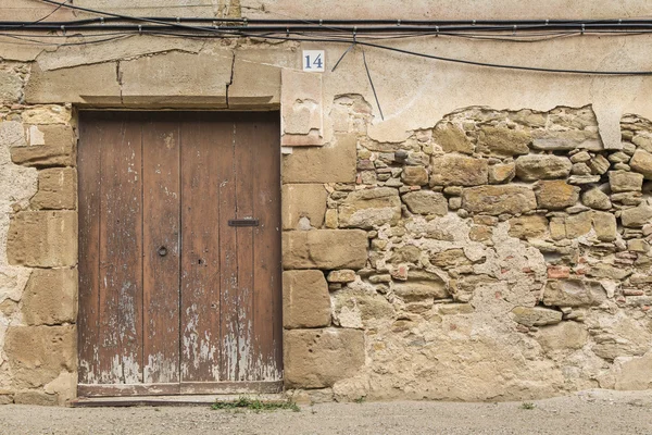 Κλειστή παλιά ξύλινη πόρτα σε τοίχο ερειπωμένο ροκ — Φωτογραφία Αρχείου