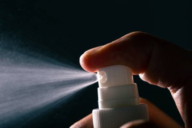 Suyu sağ eliyle sıkıyor. Parmağını kapatıyor. Siyah arka planda hala izole.