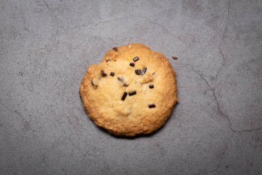 Çemberin lezzetli ev yapımı çikolatalı kurabiye ustası. Gri arka planda yapılmış.