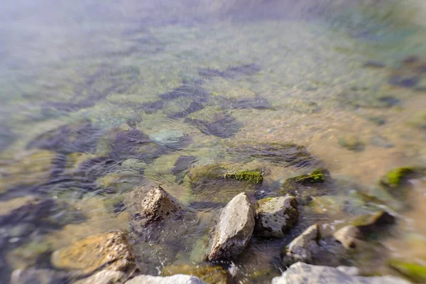 Shore rocks landscape on quiet blurry sea waters seascape