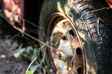 Eski ve paslı lastik araba tekerleği yakın.