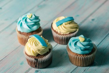 Mavi ahşap arka planda mavi ve sarı el yapımı kekler.