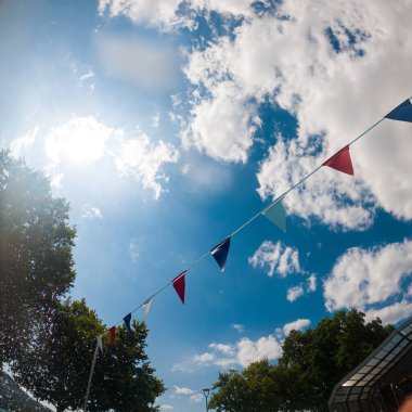 Kırmızı beyaz ve mavi bayraklar bulutlu gökyüzünü süslerken birkaç damla yağmur yağıyor.