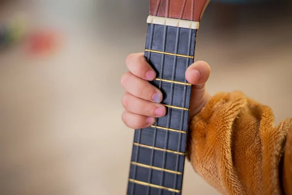 Babyhand Hält Ein Winziges Gitarrengreifbrett — Stockfoto