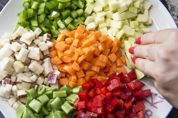 Mano blanca sirviendo verduras dados — Foto de Stock