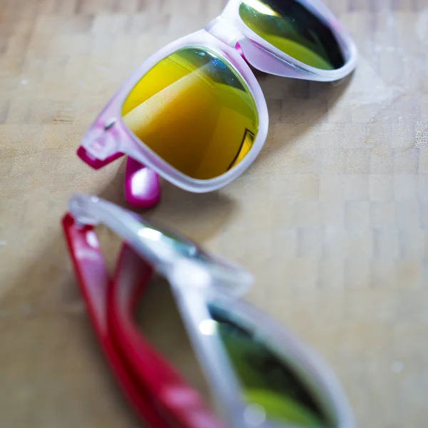 Moda ahşap arka plan üzerinde renkli Güneş gözlükleri — Stok fotoğraf