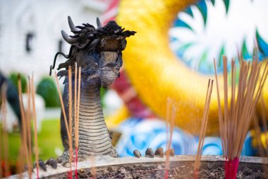 Tayland, Chiang Rai 'deki bir Budist tapınağının girişinde siyah ejderhalı tütsü tabağı heykelleri.