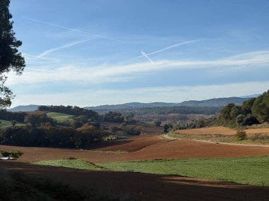 Girona, Katalonya 'da sonbahar mevsiminde kahverengi ve yeşil tarlaları ve çayırları olan güzel kırsal alan