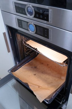 Modern mutfak elektrikli fırını boş fırın kağıdıyla ev yapımı mutfak sahnesi