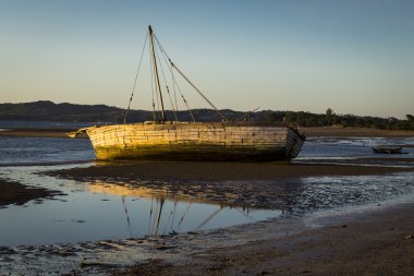 Düşük tide Madagaskar günbatımı üzerinde mahsur kalan eski beyaz gemi